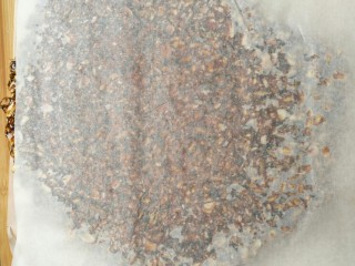 10、花生瓜籽麻糖,将拌好的花生芝麻糖浆倒在铺好的油纸上面,再在上面再铺一层油纸,趁热快速用擀面杖擀平。