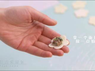 8、羊肉小水饺,拿一个面片，放一点馅，多一点馅最终鼓鼓的比较好看。另一个面片盖上，捏紧，捏起来的样子想要花纹明显，请沿着花型捏。