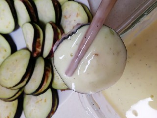 16、炸茄盒,锅里倒入适量油，中小火油温3成热，把茄盒放入面糊里裹匀。