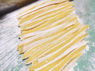 2、自制沙琪玛,鸡蛋和面粉事先混合成团,静至半天左右(时间没要求)擀平切条,撒少许面粉以防粘黏。