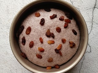 6、奶香黑米发糕,发酵至两倍大后撒上适量的葡萄干装饰表面（红枣或者坚果类都可以用来装饰，根据自己喜好）  （因为现在天气比较热了，发酵一定要注意状态，两倍大就可以了，千万不要发酵过头了，不然蒸好出锅会塌陷，影响口感）