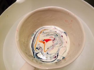 11、星空棒棒糖蛋糕,剩余的巧克力加入红色、蓝色、绿色、黄色食用色素，用牙签随意拌一下