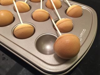 10、星空棒棒糖蛋糕,棒棒糖出炉马上脱模，一个个分别插入巧克力液内，均匀地沾上巧克力液放凉