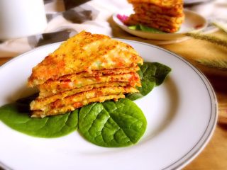 12、三文鱼时蔬蛋黄饼,放凉用刀切成小片，盘子底部铺上青菜叶，放上饼即可食用了。