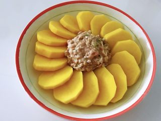 6、土豆花环,刚才拌好的肉馅，捏成圆形，放在土豆中间。