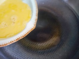 5、秋葵炒鸡蛋,热油倒入鸡蛋煎至凝固。