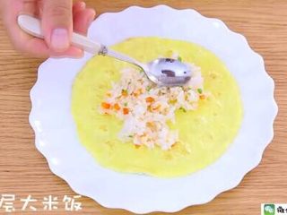 11、千层蛋包饭 宝宝辅食食谱,放入盘中一个蛋皮，铺上一层大米饭。