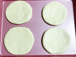 9、蓝莓芝士迷你披萨,将面团擀成圆形，披萨胚就做好了，放入烤盘中。提前预热烤箱180度预热10分钟。