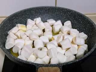 3、预热圣诞节  蔓越莓雪花酥,这时加入棉花糖，同样小火将棉花糖炒化。(一边炒一边搅拌)