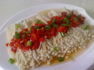 6、剁椒金针菇,放入葱花，然后炒锅放入20克的食用油，烧至冒青烟后，淋上盘即可