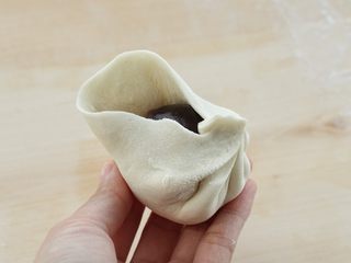 7、烫面豆沙饼,取一张饼皮放上豆沙馅，然后像包包子一样包起来，也可以按照自己的手法包，总之就是不要漏出豆沙馅