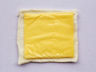 5、爆浆芝士火腿土司卷,铺上芝士。