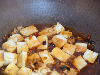 5、香辣豆腐,放入料酒、酱油、盐、加入适量的水，轻轻炒均，煮沸