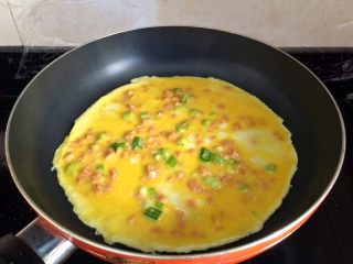 12、辅食计划+火腿葱花厚蛋烧,轻轻转动锅子，摊成圆形状，小火慢煎