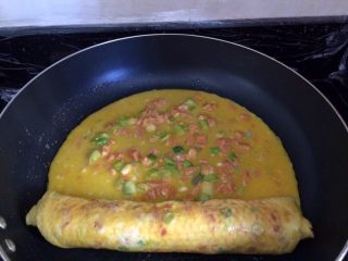 14、辅食计划+火腿葱花厚蛋烧,接着倒入剩下的一半鸡蛋液，待蛋液凝固，接着卷第二层