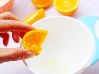 2、甜甜的橙香奶片,橙子切开，用手挤出橙子里的水分。