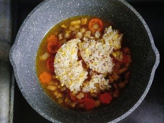6、宝宝辅食—杂蔬虾皮猪肉烩饭,煮至高汤块融化后，倒入一碗熟米饭，翻炒均匀，转小火焖煮