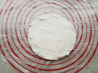 17、俄式提拉米苏,底下铺上保鲜膜,取一张饼皮,奶油涂抹均匀放在保鲜膜上。