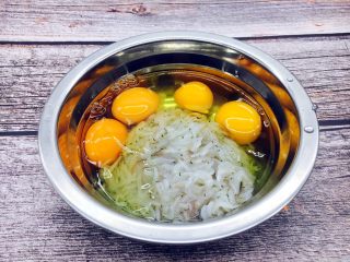4、厨房挑战 荤菜 锅塌鲜虾皮,把4个鸡蛋磕入盛有鲜虾皮的容器里。