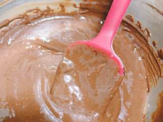 11、可可戚风蛋糕,将加入蛋黄的可可糊混合均匀，可使用搅拌勺或是电动搅拌器。