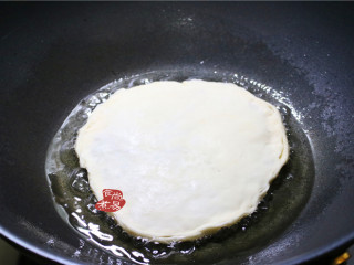 10、香葱煎肉饼,烧热煎锅,倒入少量的食用油,油温升高时,将馅饼放入锅中,先中火煎至定型。