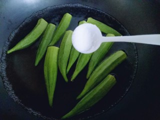 5、#咸味##养生菜#凉拌秋葵,加入一勺盐。