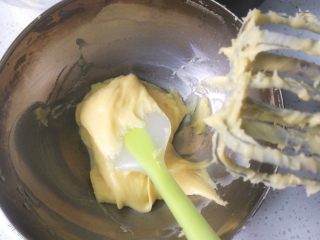 10、流心泡芙玛芬,转而用电动打蛋器，慢速搅打面糊，慢慢加入剩余的蛋液。搅打后的面糊用刮刀再拌匀，面糊富有光泽。