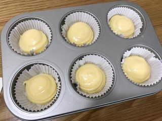 13、流心泡芙玛芬,在六连模上挤出泡芙圆形泡芙糊，这个份量刚好可以做6个泡芙玛芬杯。表面喷水或者用勺子沾水，点在泡芙糊的表面。