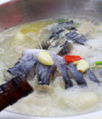 4、大蒜泡椒焖鲇鱼,接着加入高汤或者清水将鱼头鱼尾煮10分钟,放入鱼身,倒入花雕酒大火煮开后转小火焖15分钟。