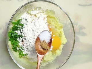 4、油炸小零食,放入葱花，胡萝卜丁，打入一个母鸡蛋，加入面粉，盐，十三香