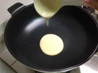 4、无油原味松饼,不粘炒锅烧热,不放油,保持小火,用汤勺舀起一勺面糊,滴落到锅中间,自然形成圆形。