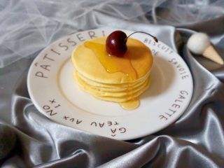 9、无油原味松饼,把所有的面糊都用完之后,把煎好的松饼叠在一起,淋上蜂蜜或枫糖,放上樱桃装饰一下,美味健康的奶香松饼就完成了。