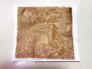 13、宝宝健康食谱  迷你小寿司,在寿司帘上放一张紫菜，粗面向上