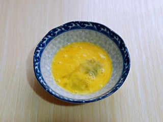 3、简单快手小零食~黑芝麻椰香吐司条,鸡蛋打入碗中,用筷子打散。