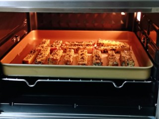 9、简单快手小零食~黑芝麻椰香吐司条,烤盘入烤箱中层。
