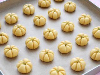 9、南瓜饼干,烤箱提前上下火160度预热，将做好的小南瓜排放烤盘内