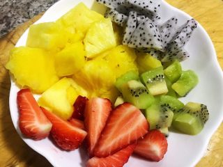 4、水果沙拉,菠萝果肉取出再将草莓、猕猴桃、火龙果切成小块备用