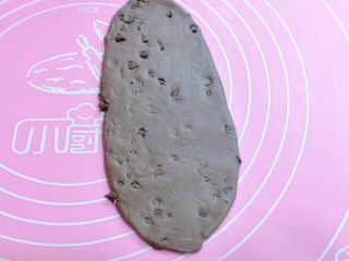 6、懒人必做～巧克力贝果,取一块醒发好的面团，用擀面杖擀成椭圆形。