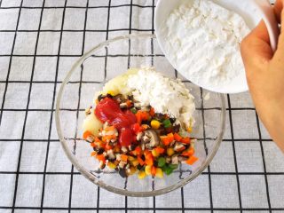 7、宝宝辅食12M➕：什锦土豆饼,将绰烫好的食材倒入土豆泥中，再加入一勺自制番茄酱和30G玉米淀粉