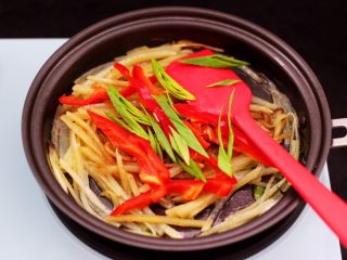 8、土豆丝红椒煎春卷,这个时候加入剩下的蒜苗和红椒丝。