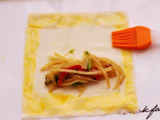 11、土豆丝红椒煎春卷,春卷皮的四周，用刷子蘸少许鸡蛋液刷均匀。
