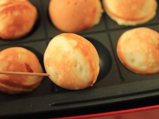 7、香蕉蛋糕球,借助牙签，快速翻转蛋糕球，继续烘烤2分钟