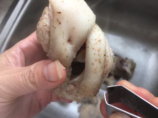 6、猪蹄汤,将水倒出.用镊子去除猪蹄上的毛