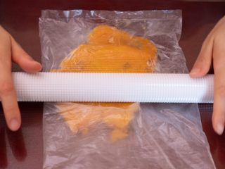 2、红薯泥甜品 ,放入保鲜袋，擀成红薯泥。