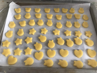 12、卡通牛奶小饼干,全部压完，放在铺好油纸的烤盘上