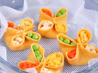 6、四喜蒸饺,往四个洞洞中填充胡萝卜、豌豆、蛋碎、豆干。包的时候宝宝已经两眼冒光了。