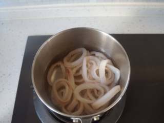 1、香酥鱿鱼圈,锅中加水烧开，放入鱿鱼圈焯烫一下，时间不要过长，以免肉质太老不好咬了