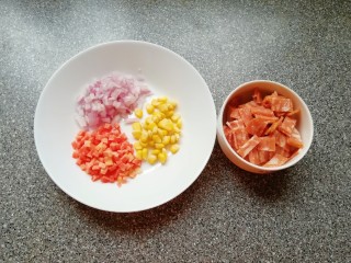 4、培根肉披萨,利用面团发酵的时间准备好披萨馅料：培根肉切成小片，洋葱红萝卜洗干净切成小丁，准备好熟的玉米粒。
