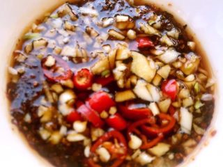 8、粉蒸茼蒿,放入涝汁、辣椒油、麻油、糖、蒜和辣椒粒搅拌均匀可口的汁就调好啦