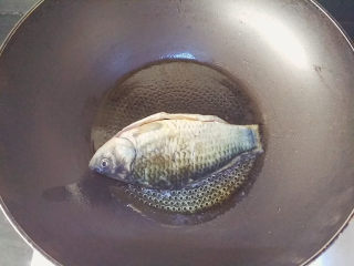 2、麻油鲫鱼浓汤,热锅后倒入麻油，烧热后下鲫鱼